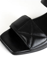 Lade das Bild in den Galerie-Viewer, Detailfoto einer minimalistischen Sandale in schwarzem Glattleder mit Karree Leisten und zwei gepolsterten Riemen mit dekorativen Nähten im Quilted-Look