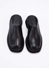 Lade das Bild in den Galerie-Viewer, Draufsicht auf ein Paar Clogs aus hochwertigem, schwarzem Leder mit dezentem Finish. Ein tolles Detail ist die erhobene Mittelnaht, die dem ansonsten puristischen Modell einen spannenden Touch verleiht. Die Schuhe sind optisch und von der Wertigkeit mit The Row vergleichbar, bieten jedoch einen erschwinglichen Preis. Cedoublé bietet klassische Ware mit besonderen Details, die keinen Trends nacheifern, sondern viele Jahre tragbar sind. Diese Clogs können mit schwarzer Schuhcreme ganz einfach gepflegt werden.