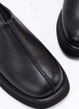 Lade das Bild in den Galerie-Viewer, Nahaufnahme der Schuhfront eines coolen Clog-Modells aus schwarzem, zertifiziertem Echtleder. Gut zu sehen ist das Design-Detail, eine raffinierte Wulstnaht, die den Schuhschaft optisch in zwei Seiten unterteilt.
