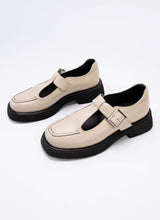 Lade das Bild in den Galerie-Viewer, Abbildung von Mary Jane Schuhen mit dezenter Plaetausohle und modelltypischem T-Strap. Das Echtleder ist in einem sanften Beigeton gehalten, alle Kontraste wie die Laufsohle, das Lederfutter und die dekorative Naht auf der Front sind schwarz.