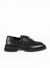 Lade das Bild in den Galerie-Viewer, Produktfoto eines burschikosen Leder Derbys mit Oxford-Schnürung und ausgeprägter Laufsohle in schwarz. Eine asymmetrische Naht ziert die Schuhfront