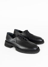 Lade das Bild in den Galerie-Viewer, Produktfoto eines schwarzen Derbys aus Leder mit Oxford-Schnürung und ausgeprägter Laufsohle. Eine asymmetrische Naht ziert die Schuhfront