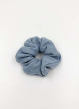 Load image into Gallery viewer, Kuschelig weiches Haargummi aus Strick. Das Material besteht aus reinem Cashmere. Die Farbe ist ein gedämpftes Babyblau.
