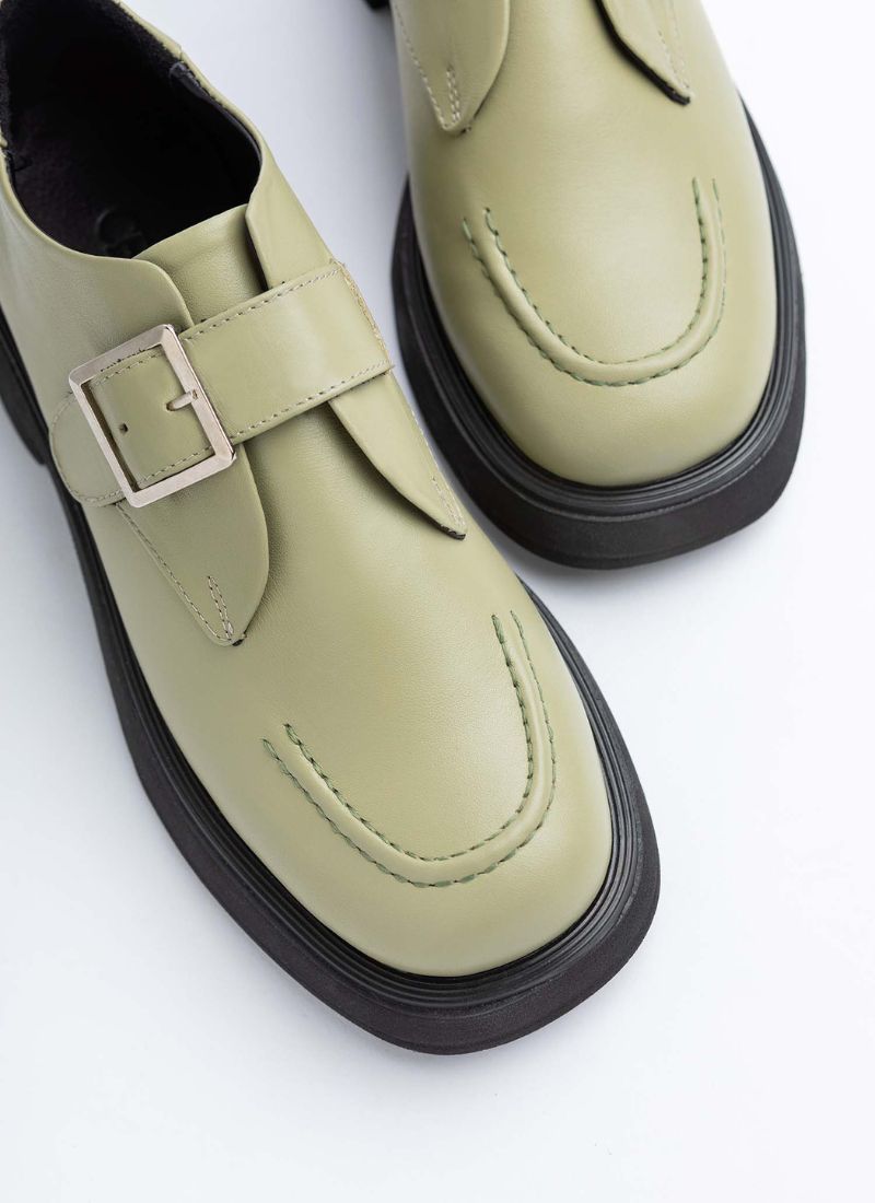 Ein Paar Lederhalbschuhe mit verstellbarer Monk-Schnalle des Herstellers Cedoublé. Das nicht geschlechterspezifische Modell ist in einem hellen Maigrün, das Obermaterial ist hochwertiges Glattleder. Die leicht abgerundete Karree-Schuhfront sowie die dezente Plateausohle lassen den Schuh avantgardistisch wirken.