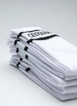 Load image into Gallery viewer, Aufeinander gestapelte Tennissocken des Labels Cedoublé in weiß-schwarz mit Logo. Es handelt sich um ein Produktbild. Auf dem Foto gut ersichtlich ist die Qualität aus Bio-Baumwolle. Die Strümpfe sind unisex tragbar.
